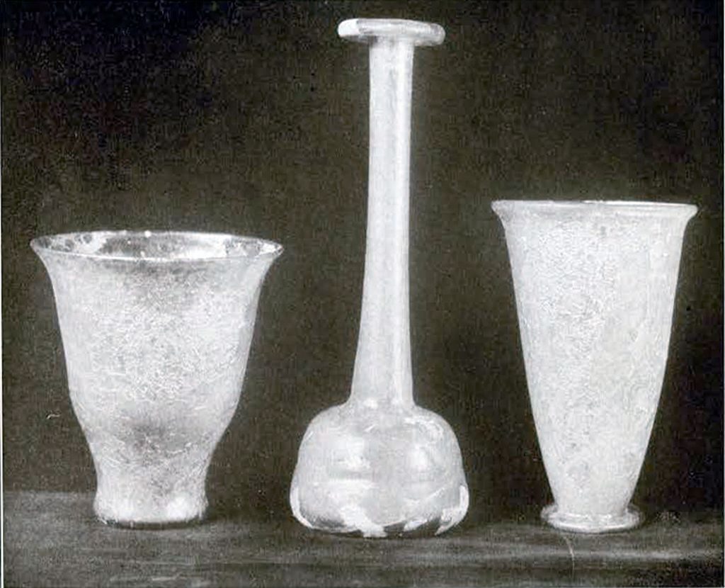 Two tall cups and a flask with a tall, narrow neck