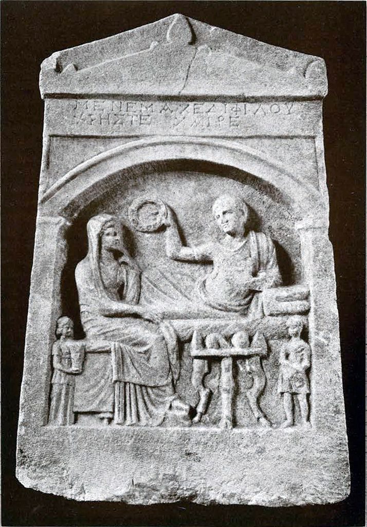 Marble grave stele with relief of a funeral banquet in an arched recess