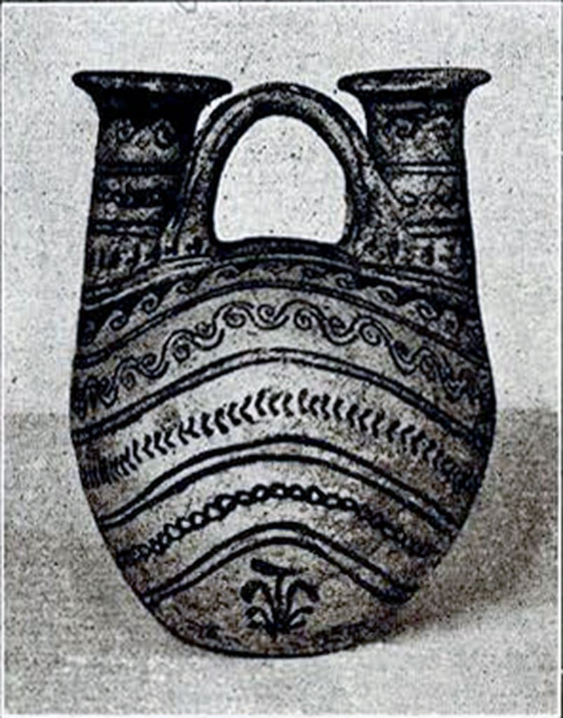 A double spouted ceramic askos with a handle between the necks