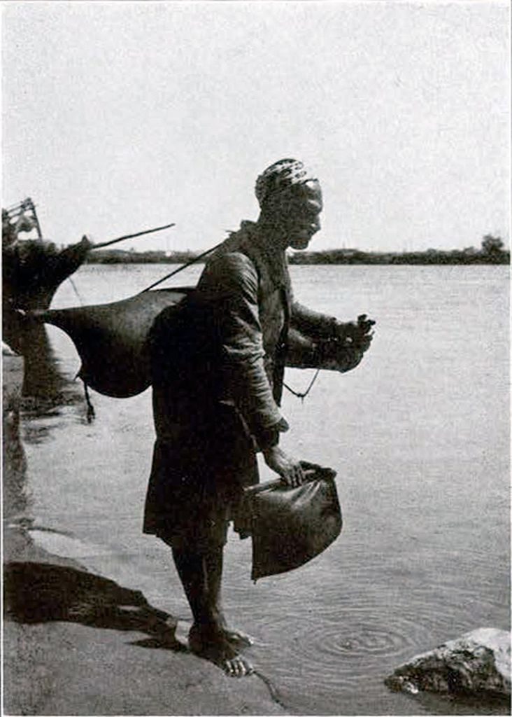A man filling his water skin at the Nile
