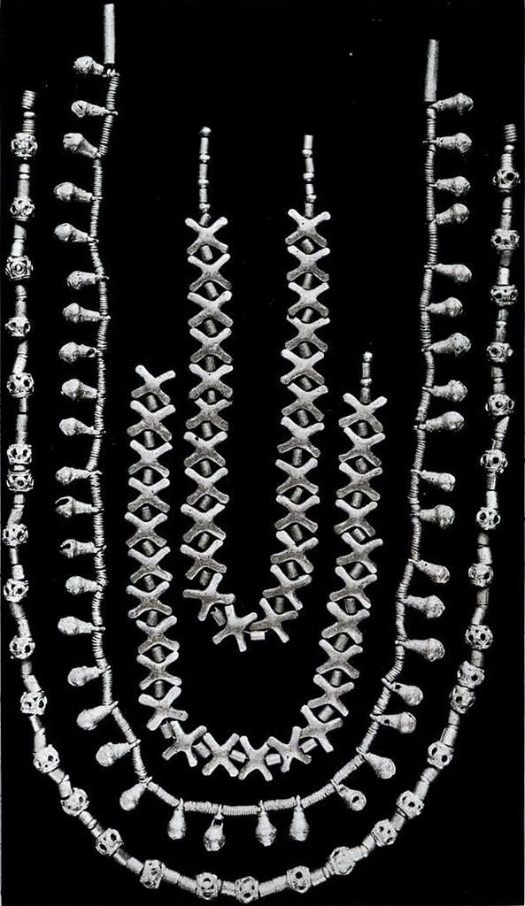 Four strands of gold beads, two with crosses, one with bells, and one with balls
