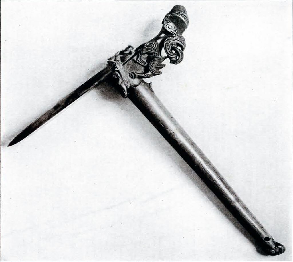 A war axe with a thin, wide, flat pick and intricate human figure