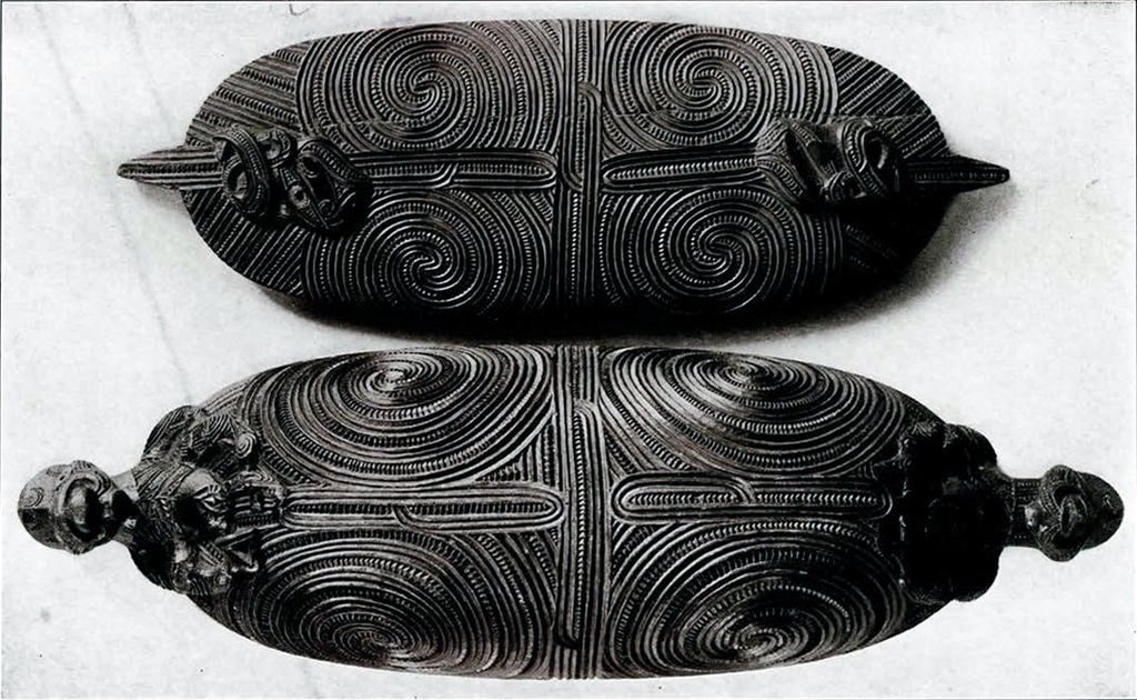 Lid and bottom of a carved wood box with large spiral motifs and female figures at either end