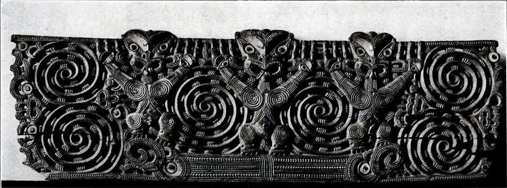 A carved wooden lintel showing three figures and six large spirals