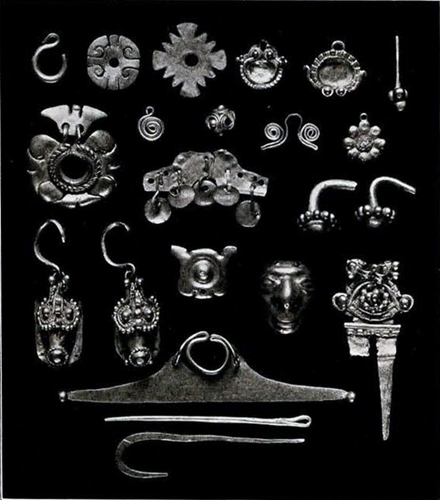 An assortment of small decorative gold objects, including earrings and piercing tools