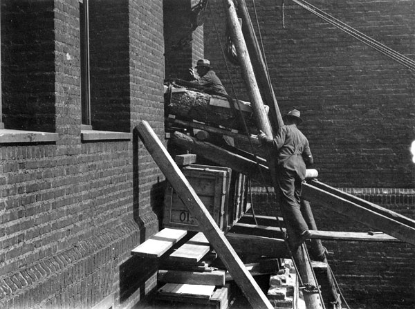 Stela being hoisted through a window.