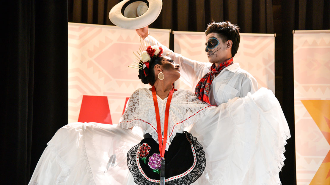 Two dancers performing on Dia de los Muertos. class=ratio-8x5