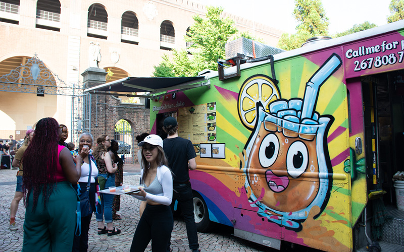 People lining up outside a food truck.