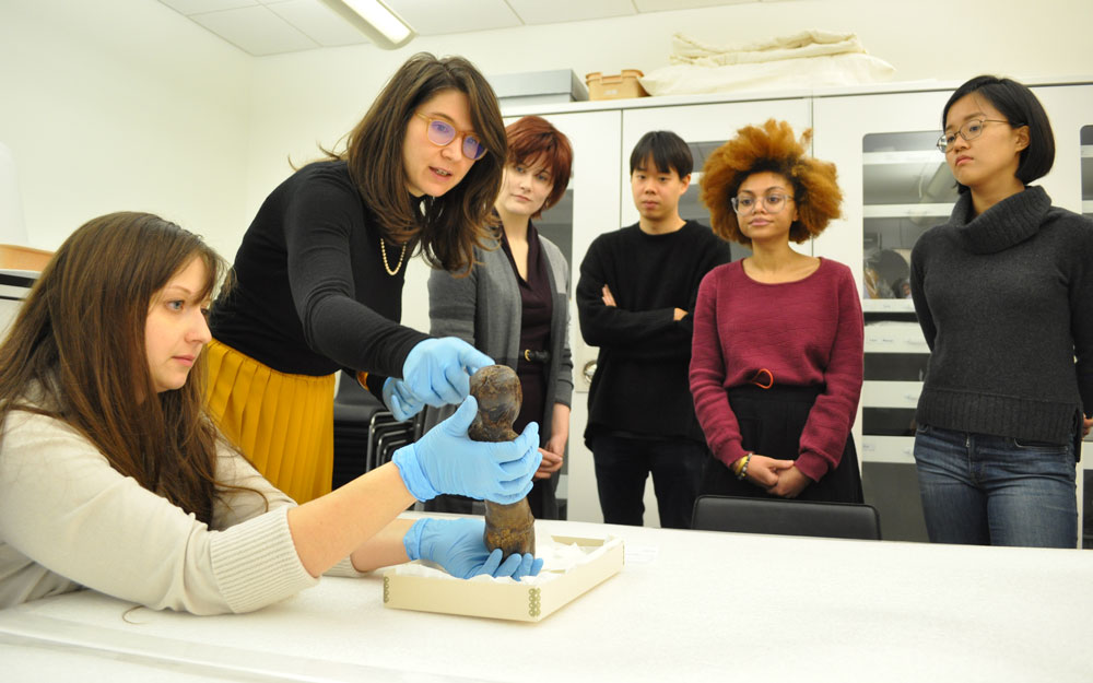 A Penn class in the Collections Study Room examining an object.