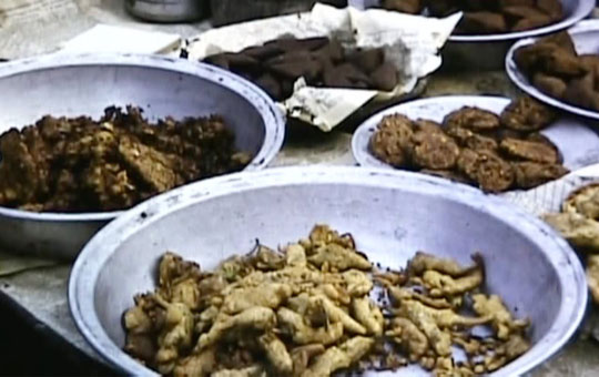 Food for sale in large metal bowls.