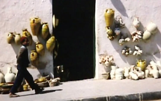 Pottery for sale outside a stone building.