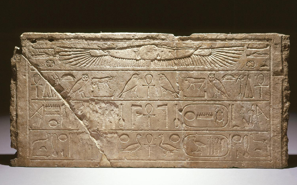 Lintel with winged sun disk and three lines of inscription. The cartouches of Tuthmosis III and defaced cartouches of Queen Hatshepsut.