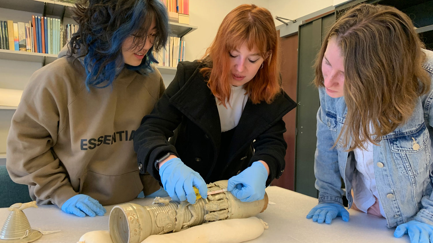 Student interns examining artifacts in a lab.