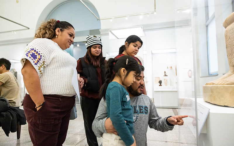 A family looking at an object on display.