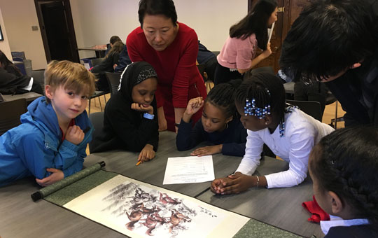 Students studying a Chinese scroll illustration.