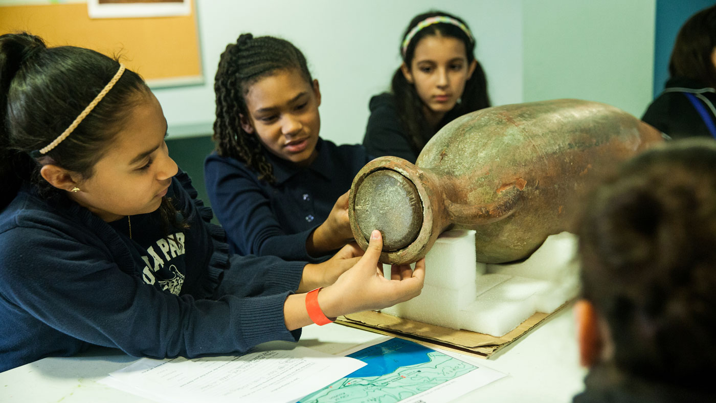 Students working with an artifact replica.