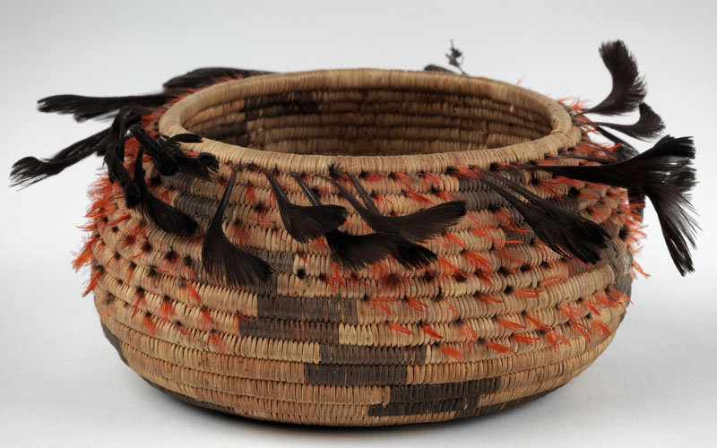 A woven basket with feathers.