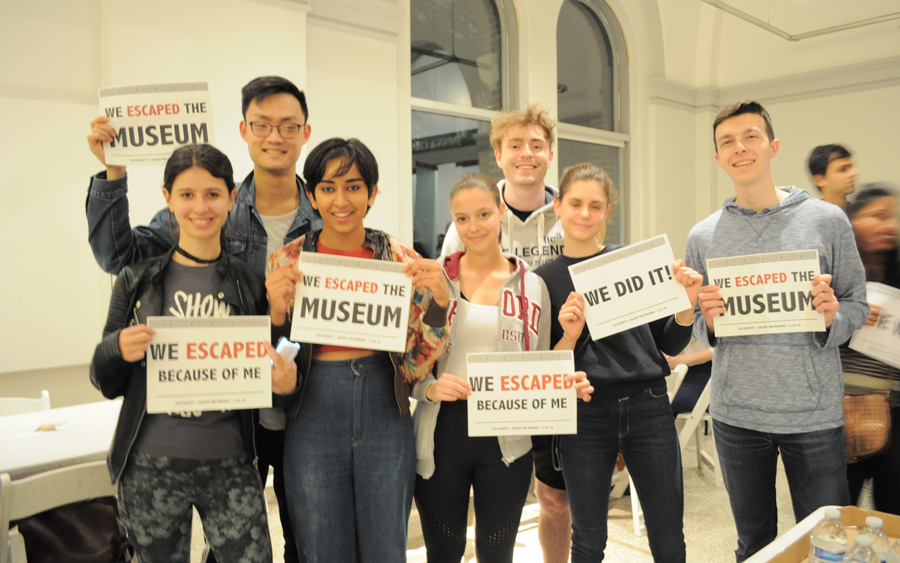 Students holding 'we escaped the museum' signs.
