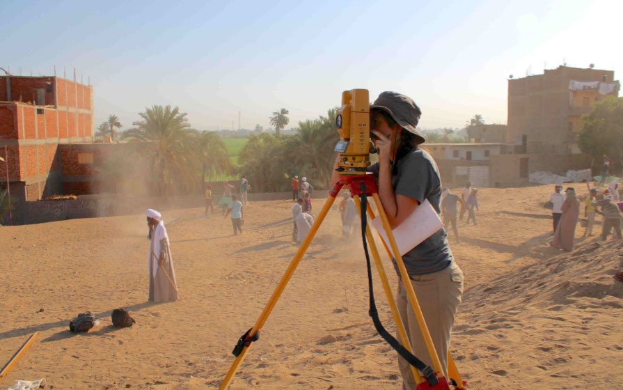 A student surveying in the field.