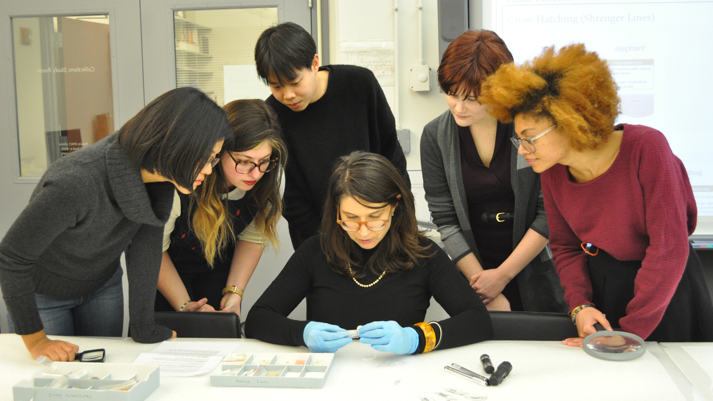 Students in the archives learning about and handling an artifact with an instructor.