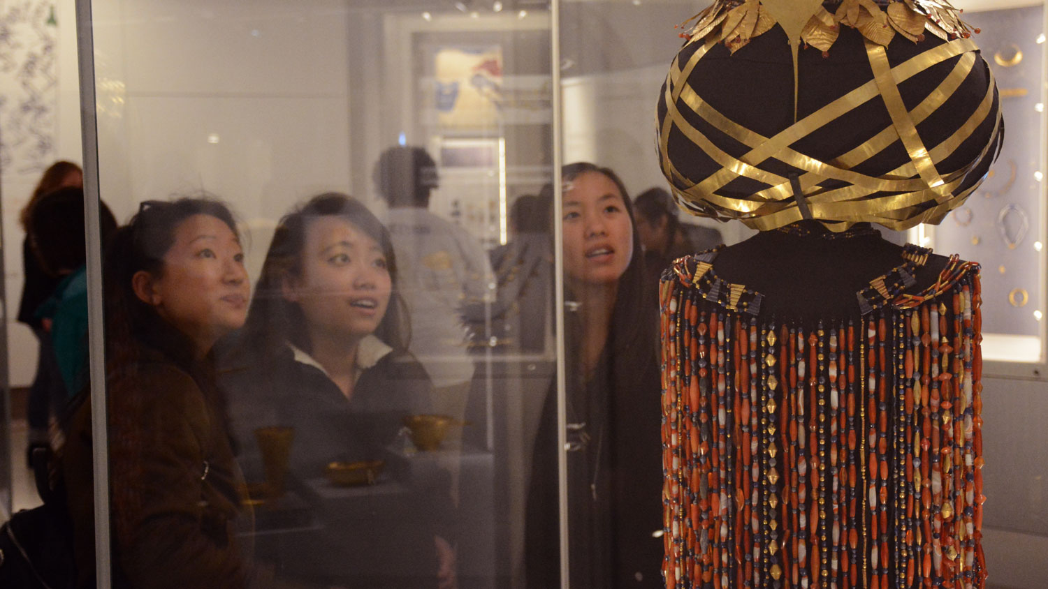 Three students admiring Queen Puabi's headdress.