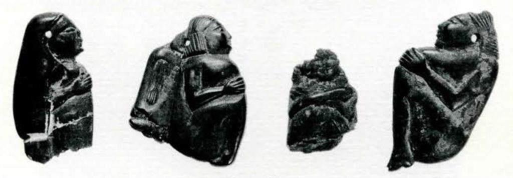 Four small amber figurines of people in different positions
