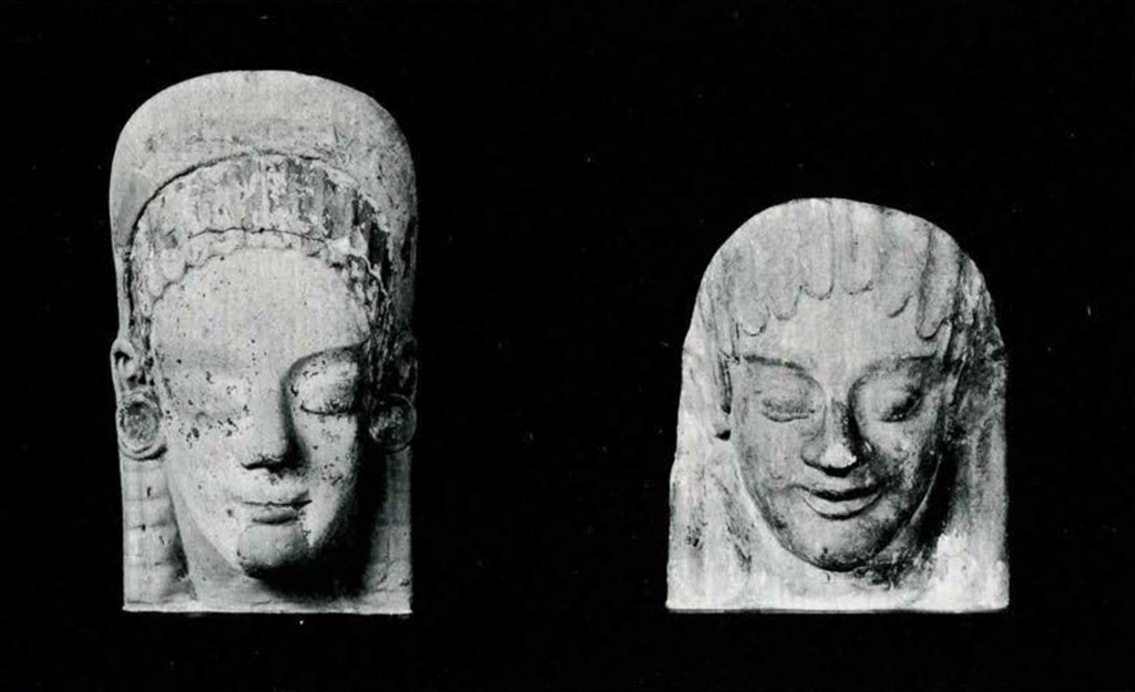 Two carved female heads with Egyptianized hair