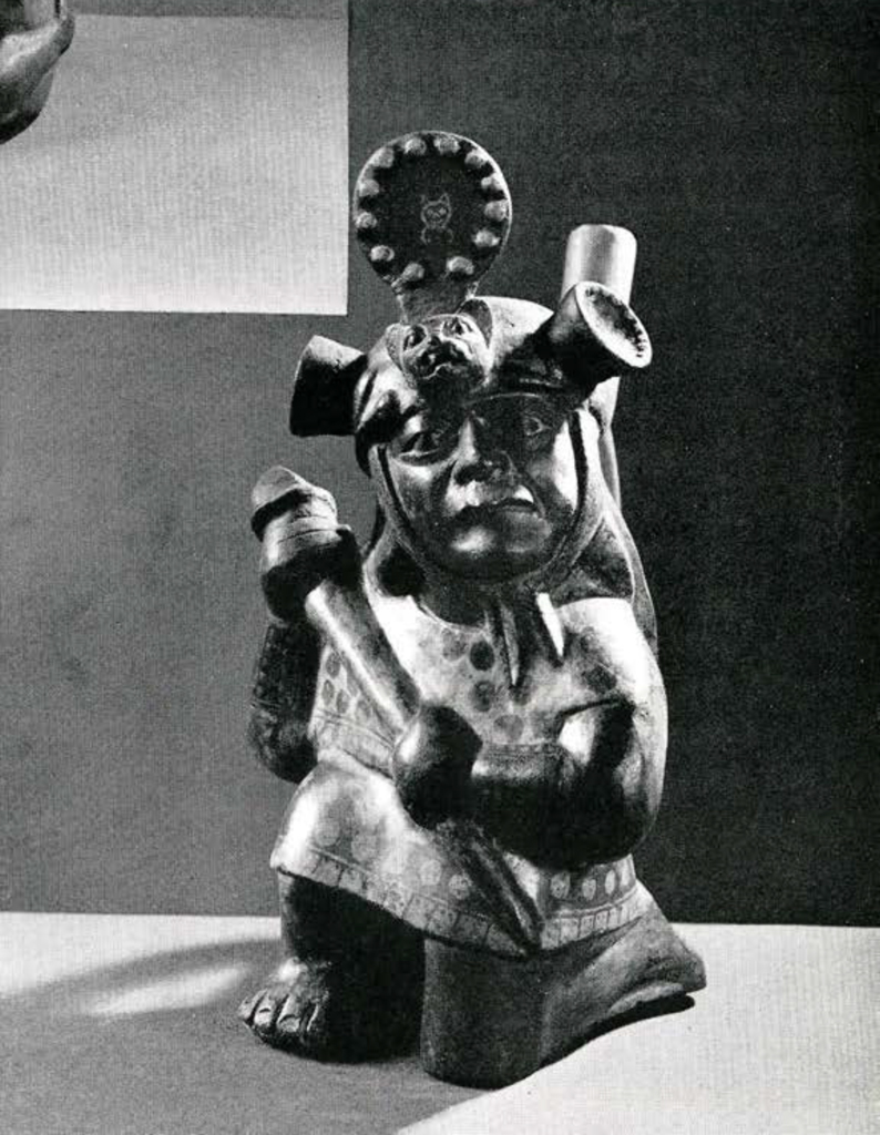 Stirrup spout effigy vessel of a man kneeling on one knee holding a war club, with a headdress in the shape of a jaguar head