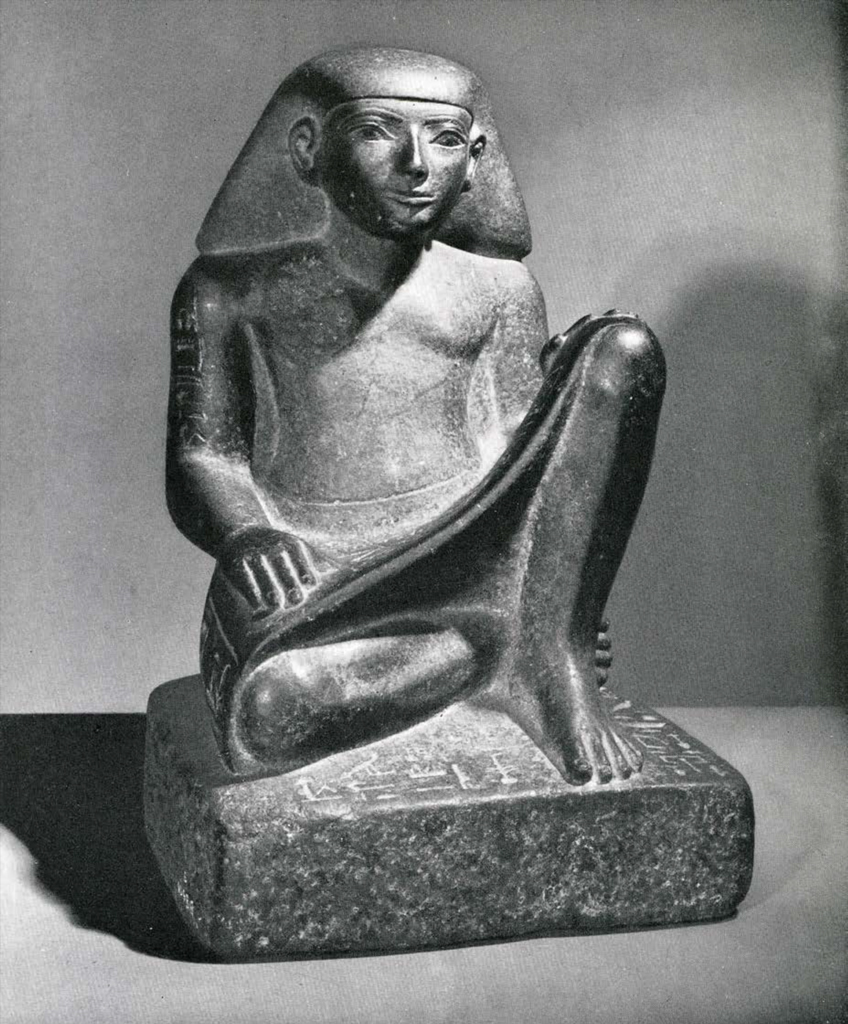 Seated statue of a scribe wearing a short kilt and a short wig, papyrus in his lap
