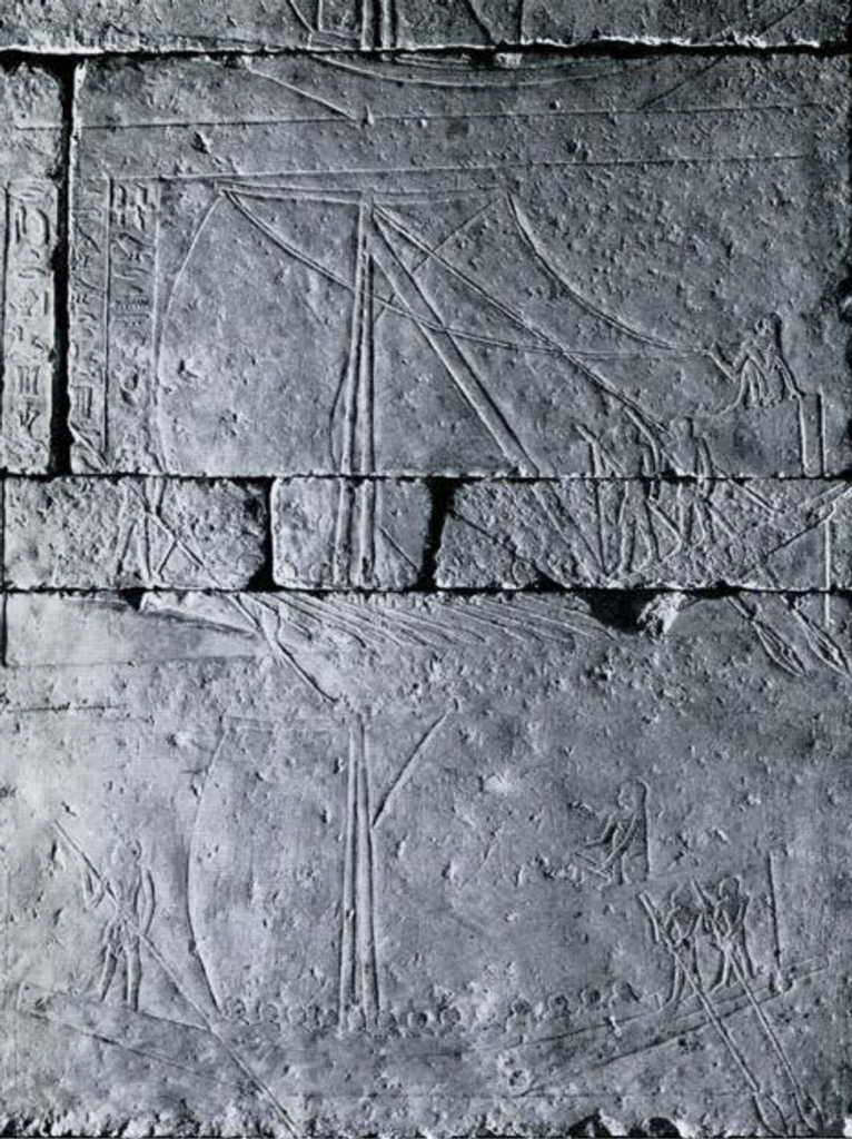 A low relief on stone wall showing ships sailing with men standing at the prow with steering paddles