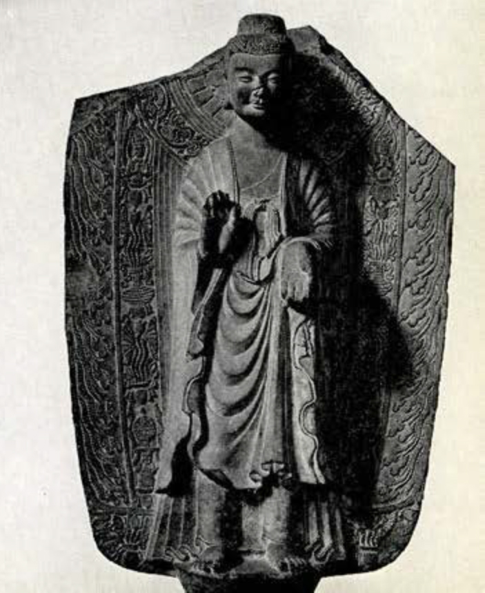 Obverse of a stone statue showing standing Sakyamuni Buddha in varada and abhaya mudras
