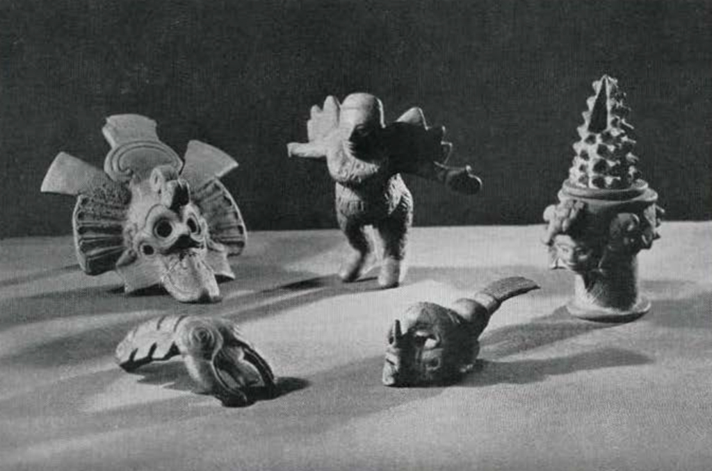 An assortment of pottery objects, including a lobster figurine and bee god figurine