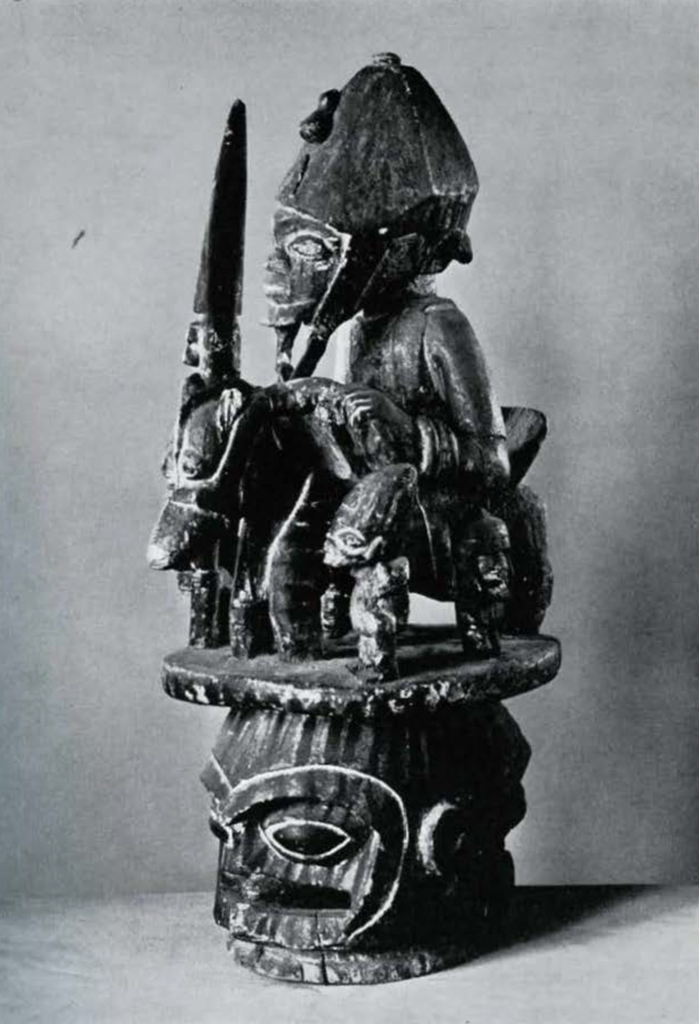 Wooden sculpture of a man with spear and helmet riding a horse, surrounded by attendants