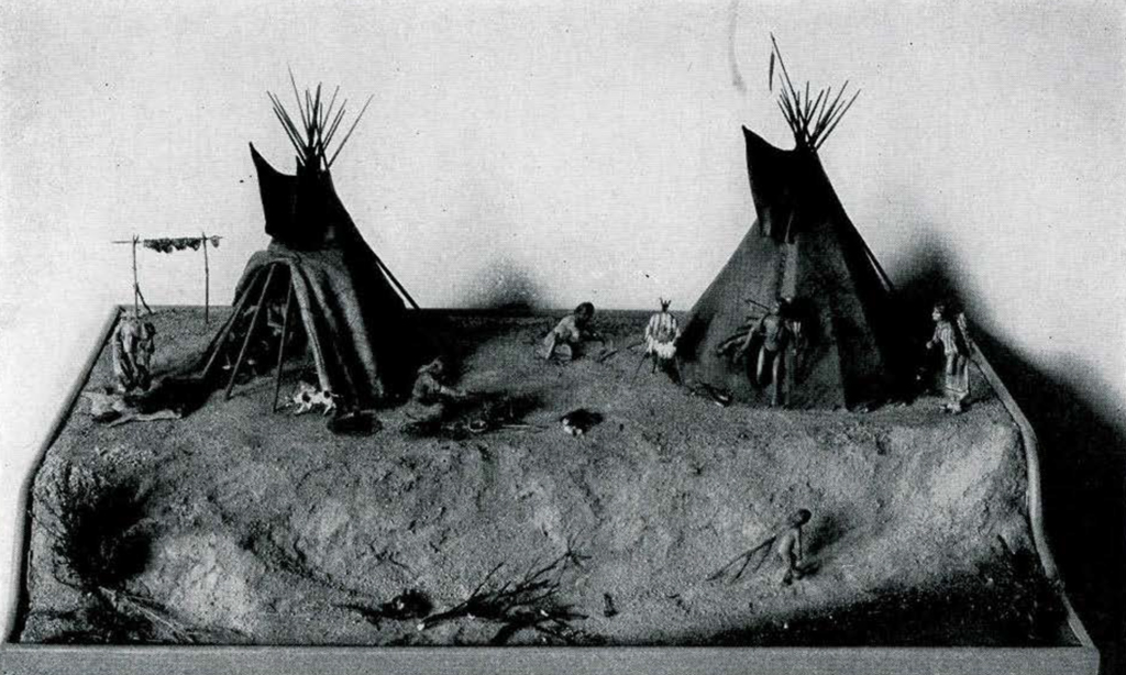 Model diorama of two tipis and a roasting spit