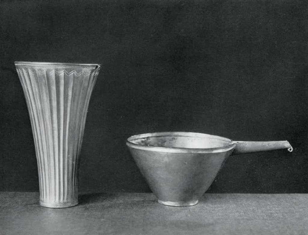 A fluted gold cup and a gold bowl with a spout