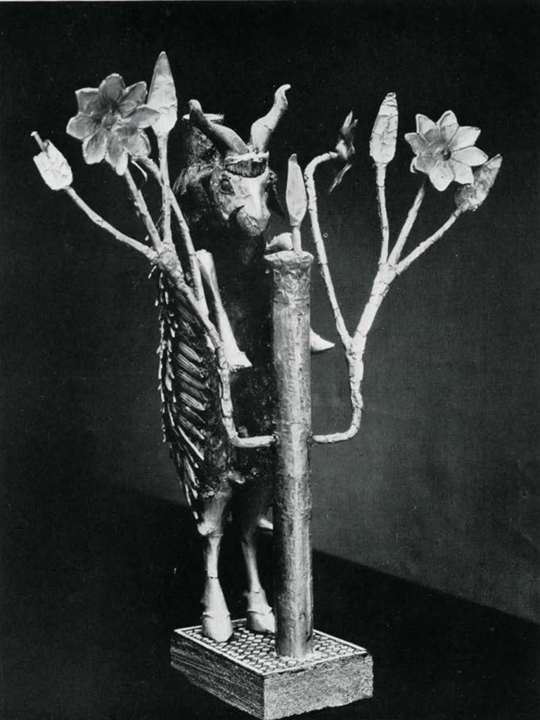 Statuette of a goat standing on its back legs to feed on leaves in a tree