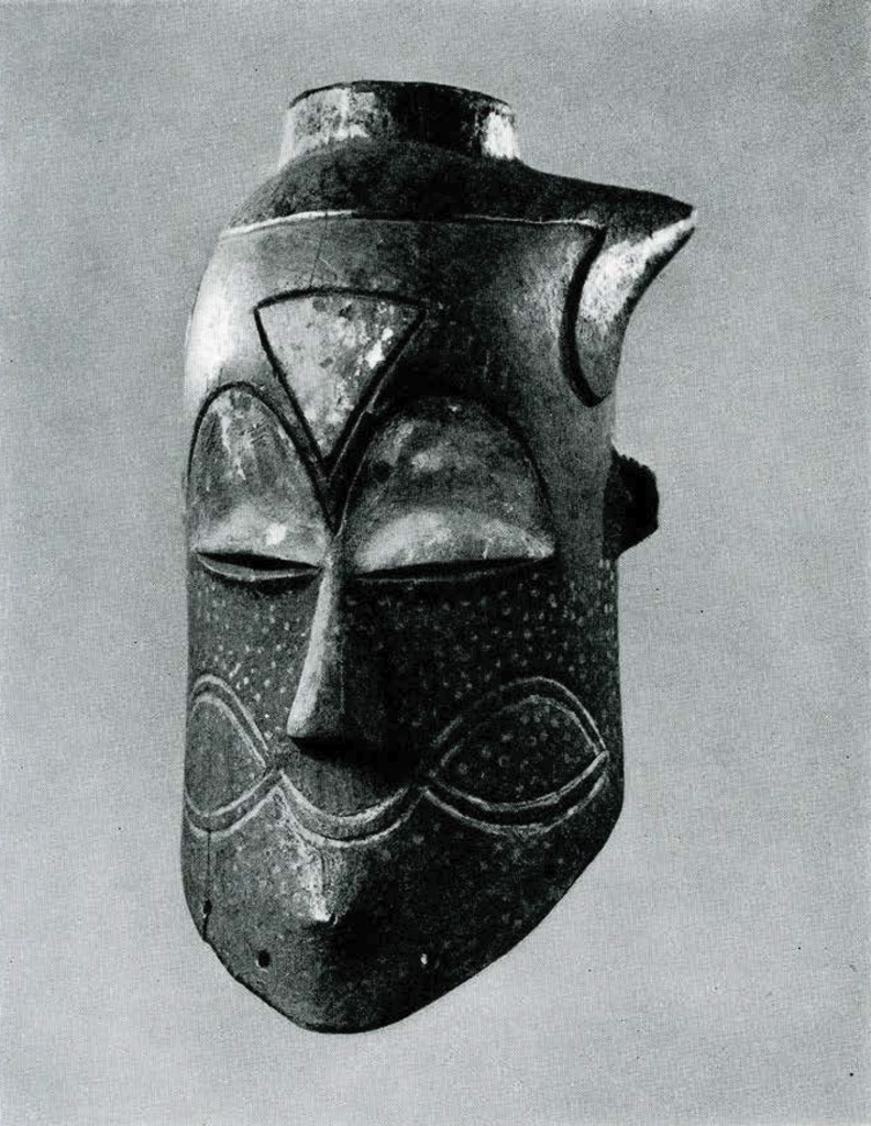 Wood mask with sharp chin and incised patterns with white paint.