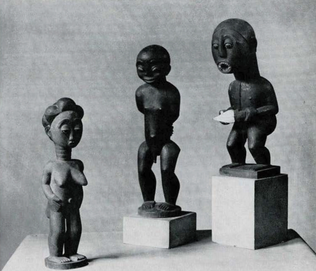 Three small wooden figures of nude people, two men and a woman.