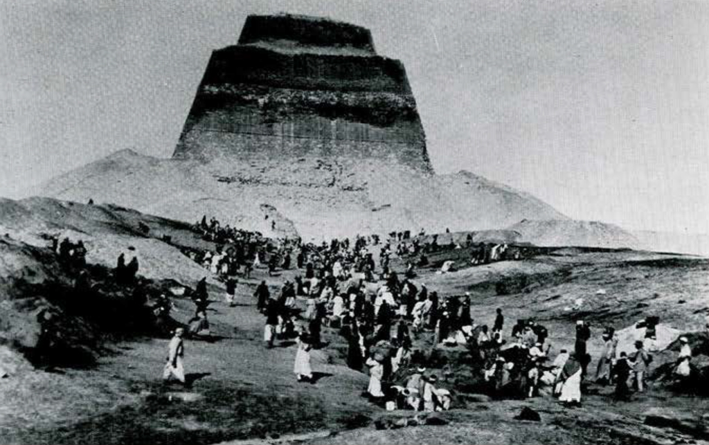 A huge number of workmen clearing the causeway leading up to the Pyramid of Snefru, the pyramid in the distance in the background.