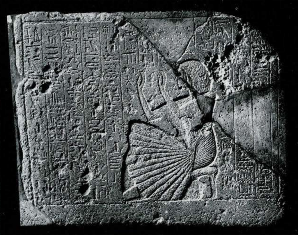 Relief of inscriptions and a kneeling figure praying.