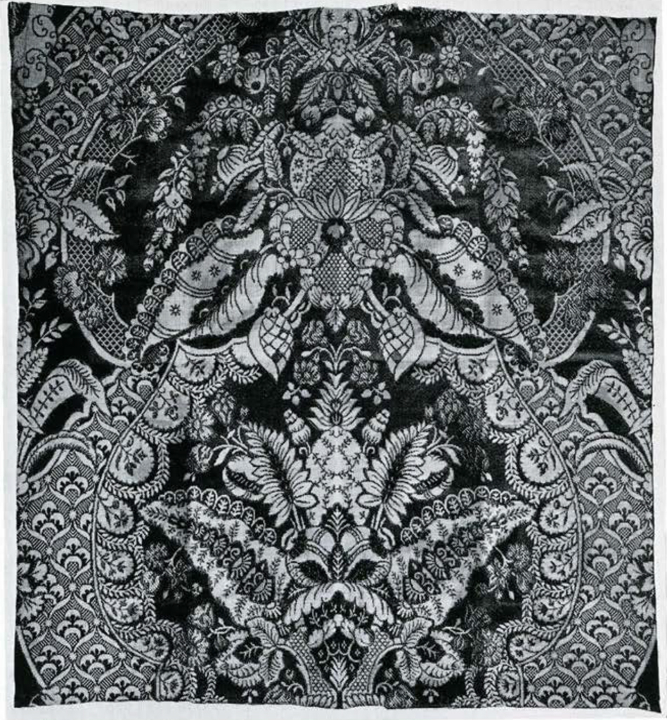 Fragment of satin with ornate symmetrical floral design.