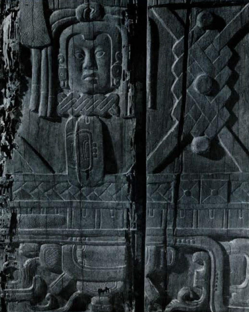Close up of carvings, showing a face and geometric patterns.