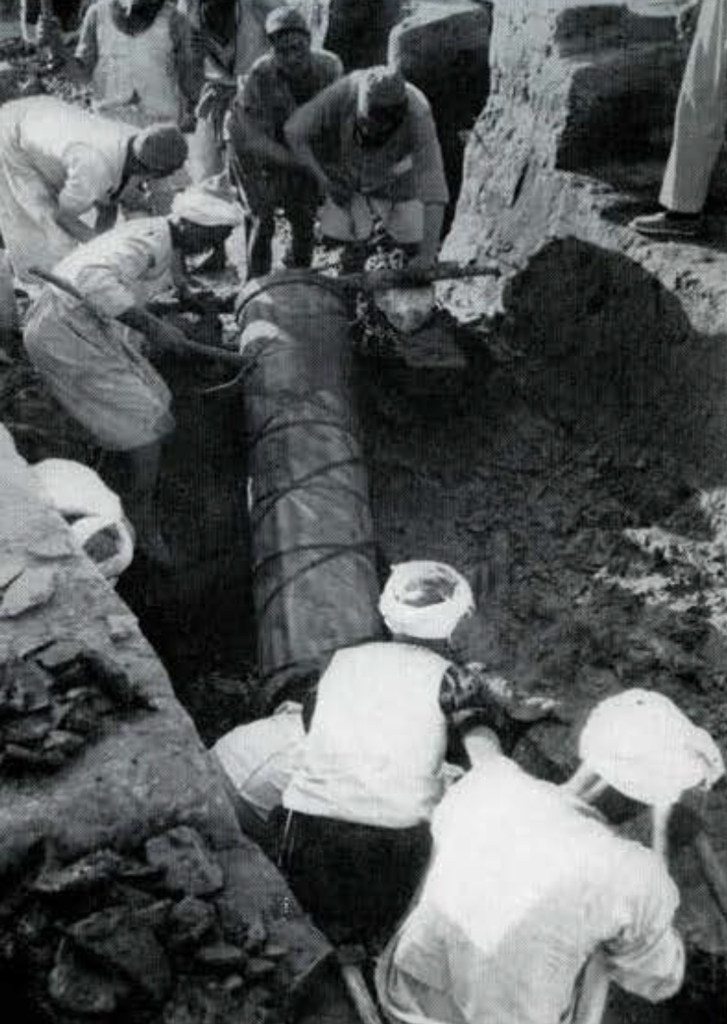 A group of men using a tambour to empty water from a tomb.