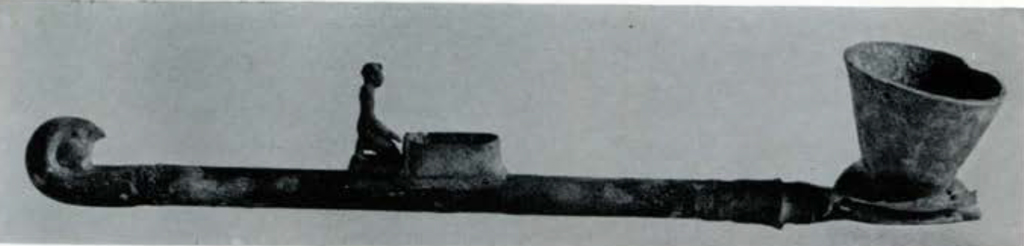 A long censer with conical bowl and figure kneeling midway down the shaft.