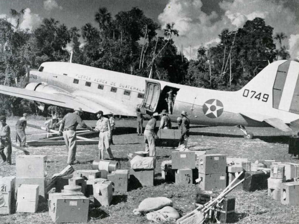 People unloading crates from a small airplane.
