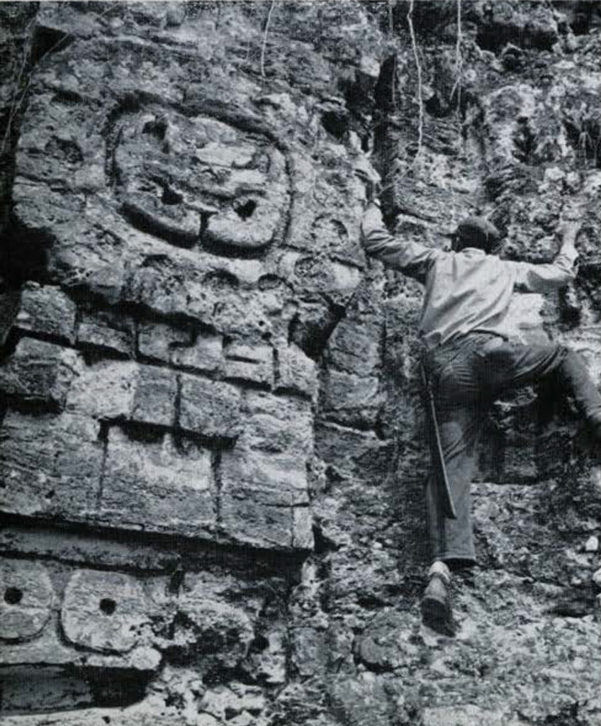A man climbing the a carved temple wall.