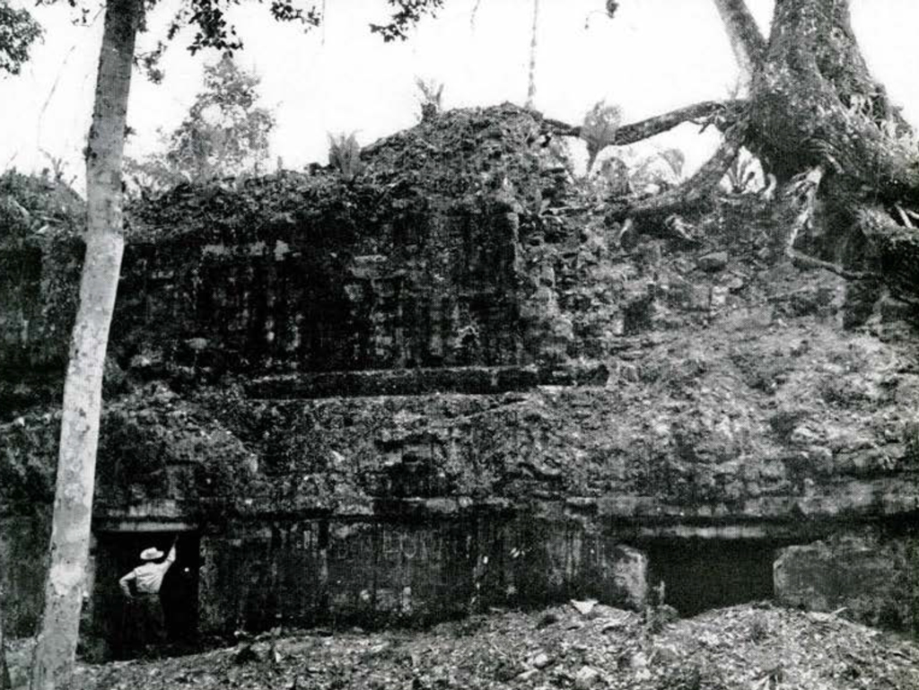 A crumbled and worn away stone wall of a two story stone building.