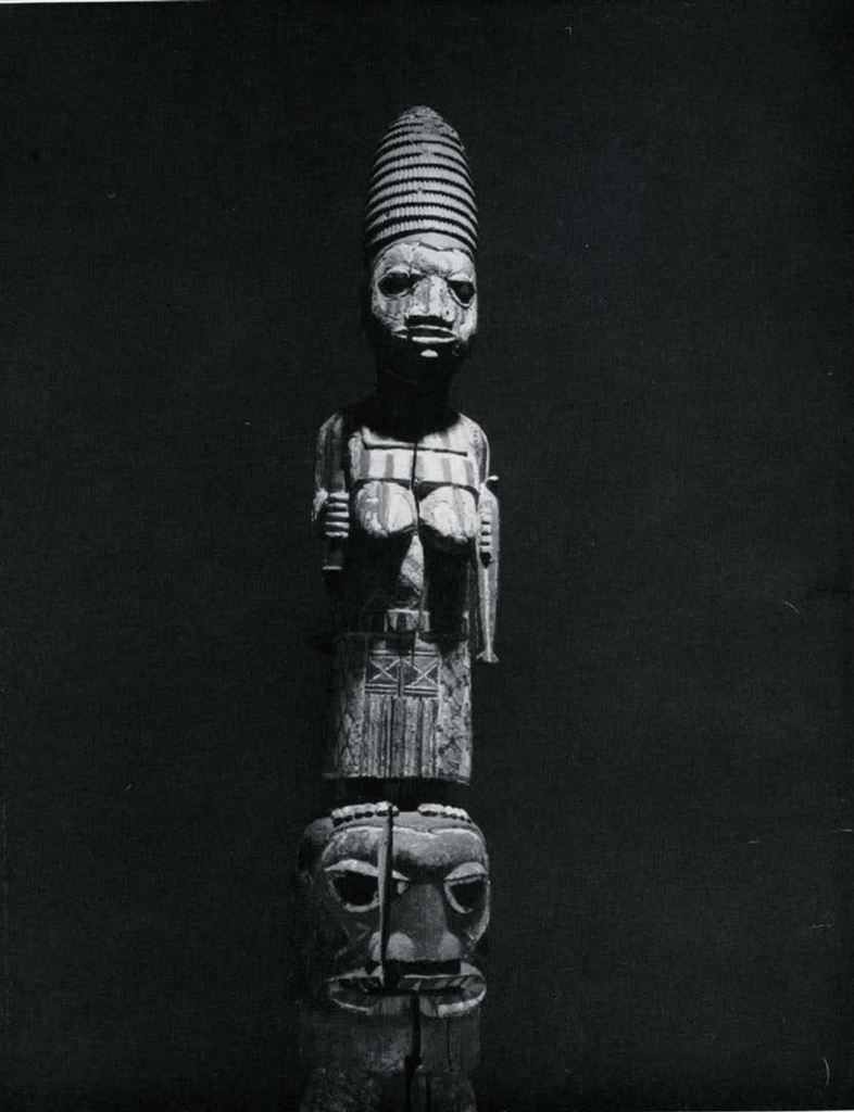 Wood mask with a figure of a woman on top, a child on her back.
