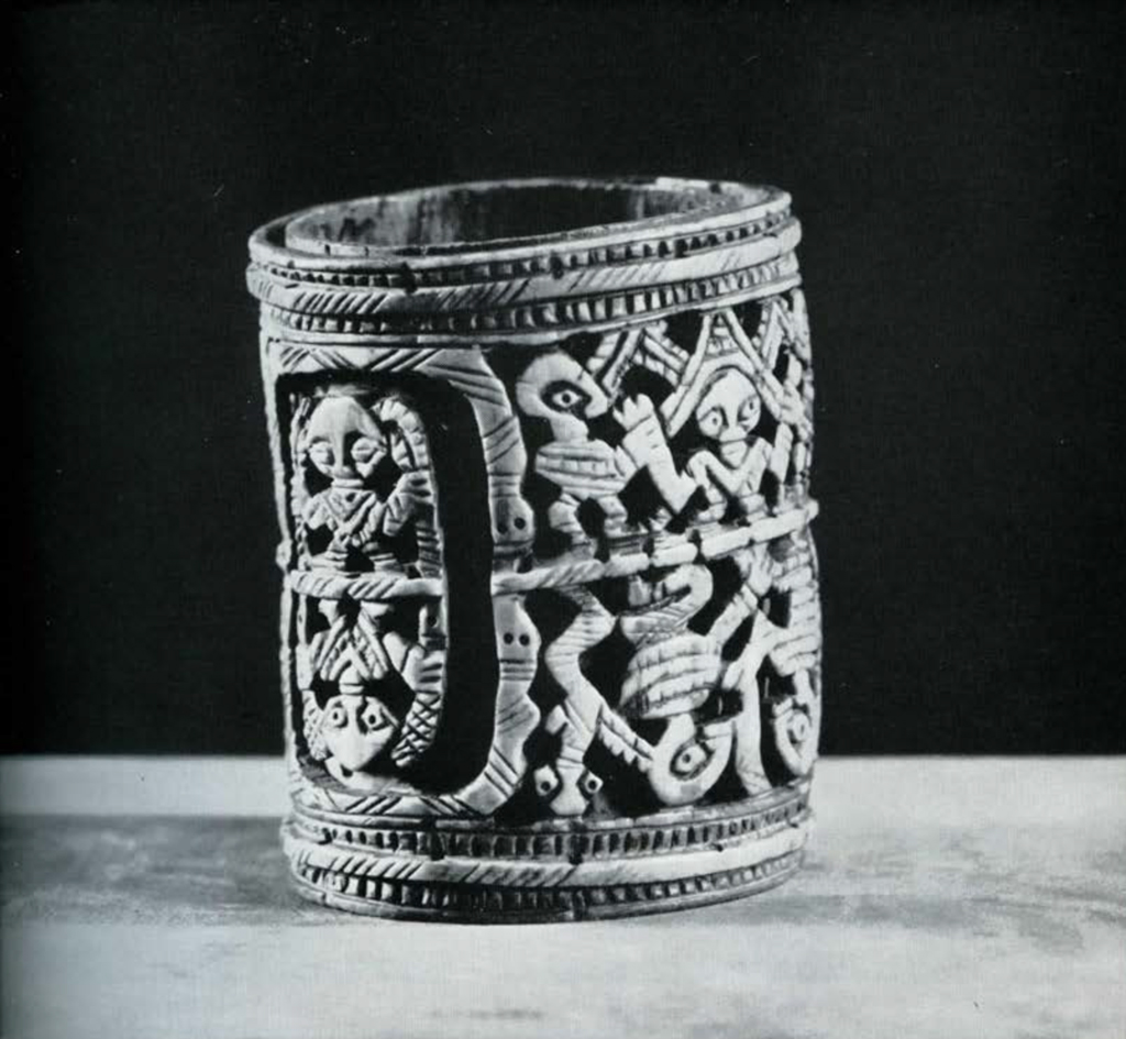 Armlet with two registers of carved figures and animals.