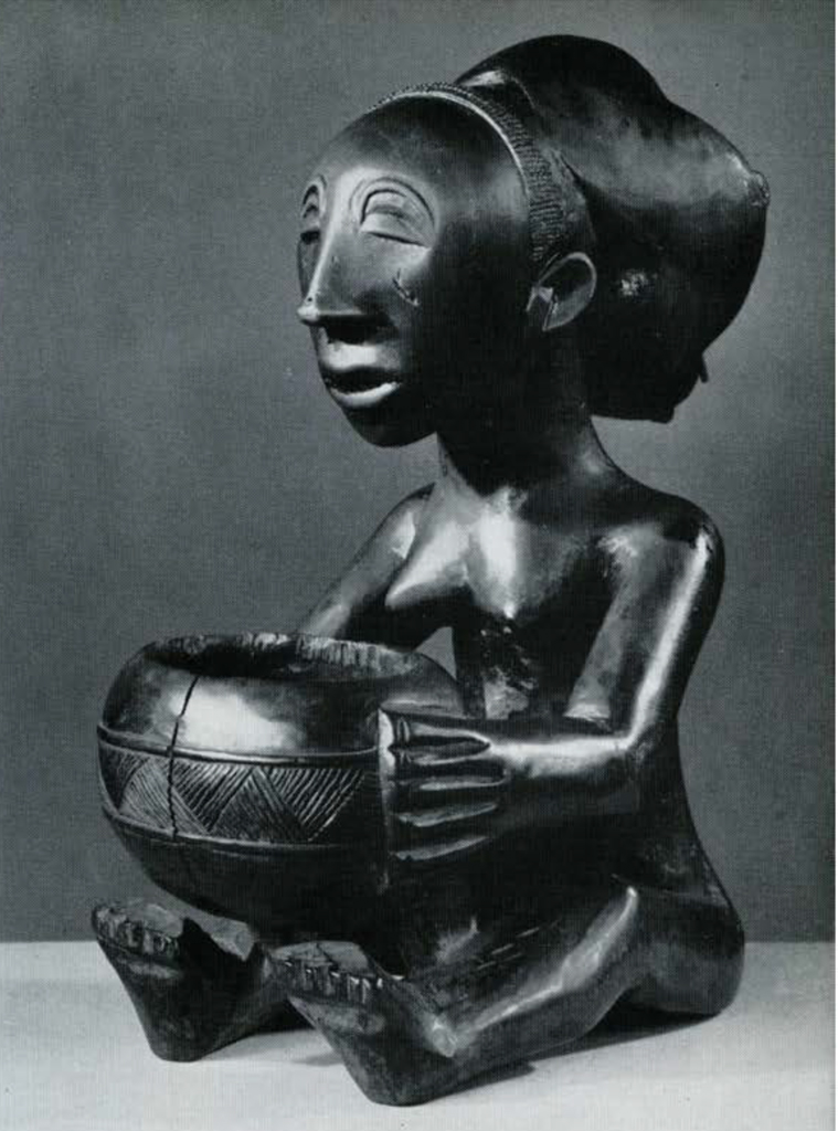 Wooden figure of a seated woman holding a bowl in her lap.